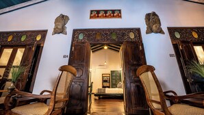 A traditional wooden entrance with two doors, a hanging light fixture, and a framed artwork above. - Beautiful villa with pool in charming Galle (Galle)