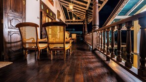 A wooden hallway with a ceiling supported by columns, a staircase with a railing, and a door with a number 604 on it. - Beautiful villa with pool in charming Galle (Galle)