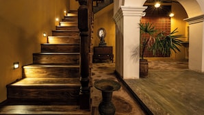 A wooden staircase with a balustrade, a potted plant, and a wall-mounted mirror. - Beautiful villa with pool in charming Galle (Galle)