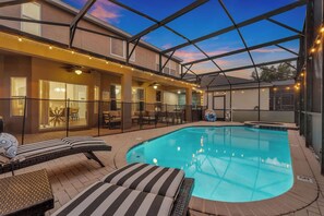An indoor swimming pool with lounge chairs, a hot tub, and string lights. - Castle Bunks & Viking Ship, Pool+Spa, 8 Min Disney (Kissimmee)