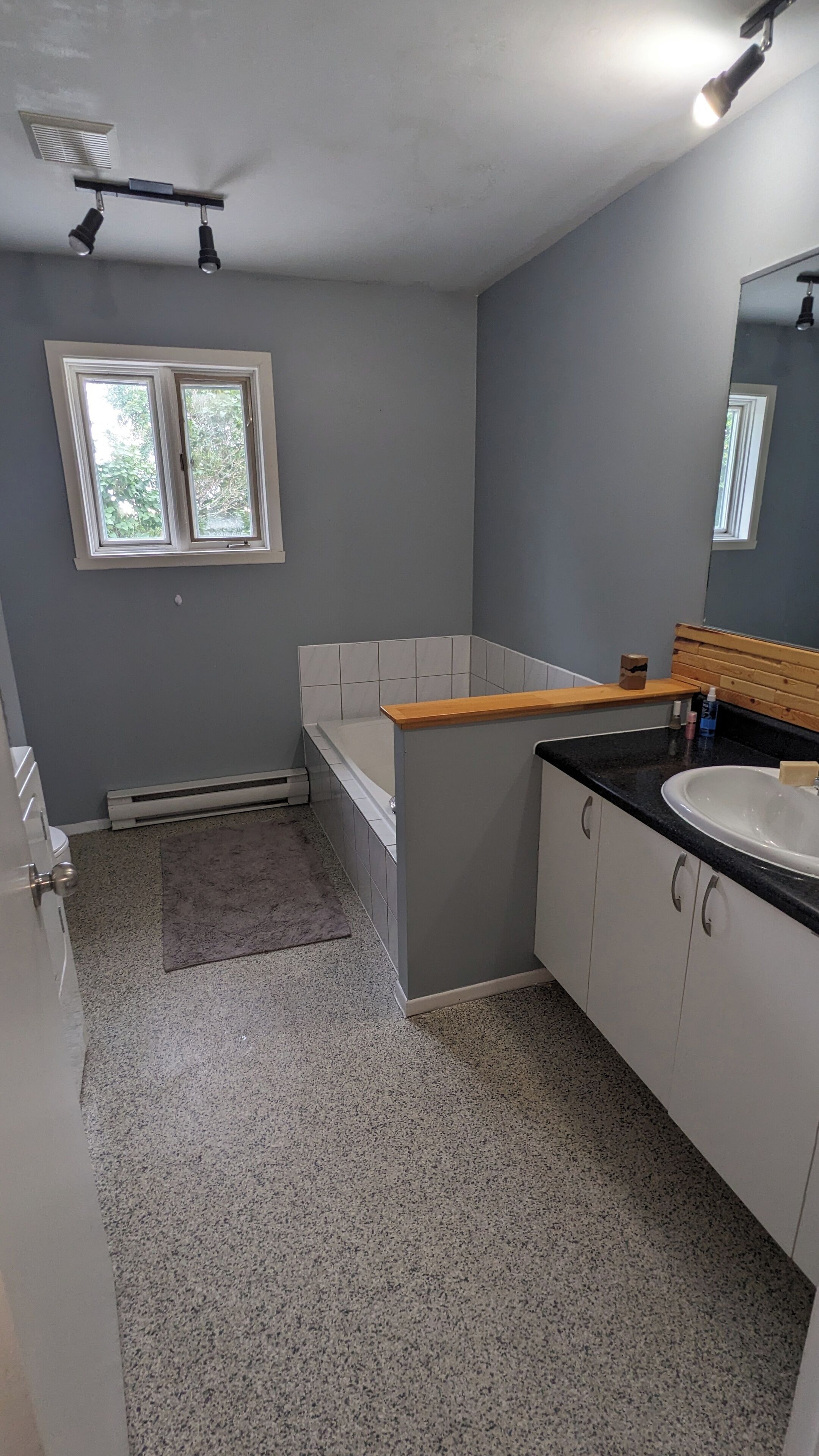 Een badkamer met een bad, een wastafel en een raam.