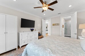 A bedroom with a large bed, a ceiling fan, a TV, a dresser, and a walk-in closet. - Cape San Blas Home, Sleeps 12 w/ Yoga Station (Port St. Joe)