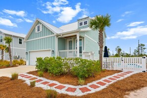 A two-story house with a garage, a front porch, and a pool area. - Cape San Blas Home, Sleeps 12 w/ Yoga Station (Port St. Joe)