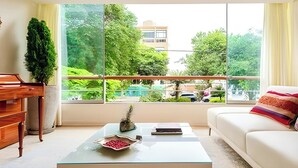 A modern living room with a glass coffee table, a sofa, and a piano. - ✶ Kotosh Residence ✶ LUXURY Best Location | Piano (Miraflores)