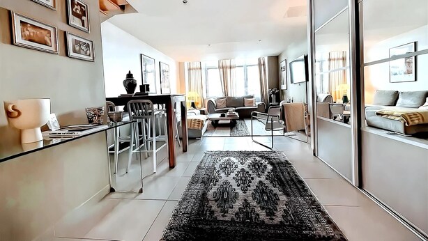 A modern living room with a sofa, coffee table, and a glass partition.
