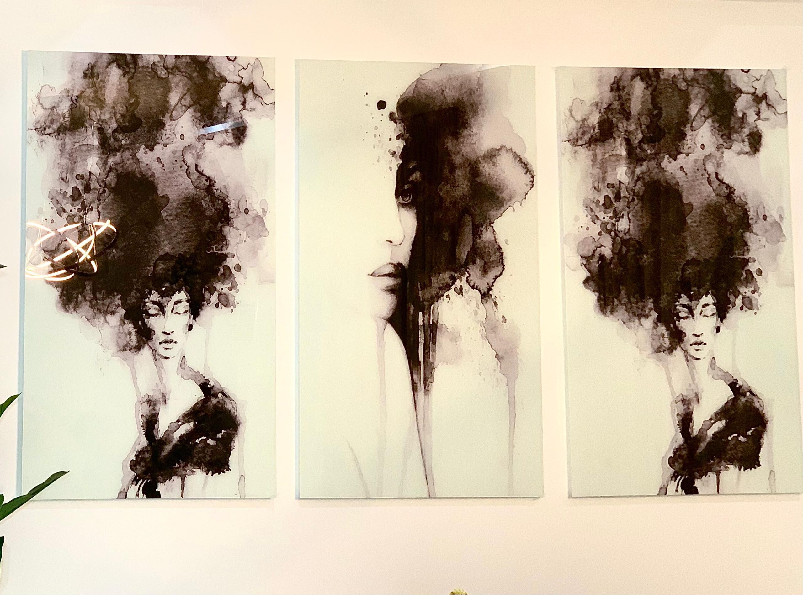 Three abstract paintings on a wall.