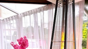 A room with a pink sofa, a vase with pink flowers, and a pink teddy bear. - Pousada Pink Village  (Campos do Jordão)