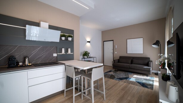 A modern kitchen with a white countertop, a built-in oven, and a coffee maker. - Appartamento bilocale ARCADIA (Verona)