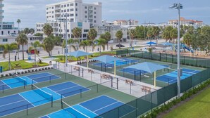 Ein Tennisplatzkomplex mit mehreren Plätzen, Sitzbereichen und einem Spielplatz.