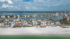 Eine Küstenstadt mit Strand, Gebäuden und einem Yachthafen.