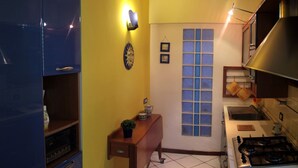 Una cucina compatta con fornello, lavello e un piccolo finestrino.