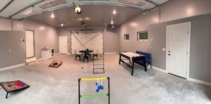 A spacious room with a high ceiling, a pool table, a ping pong table, and a small kitchen area. - Heart of Door County Home-Sleeps 16+ w/Hot Tub (Egg Harbor)
