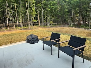 Two black chairs with wooden armrests on a white patio. - Heart of Door County Home-Sleeps 16+ w/Hot Tub (Egg Harbor)