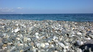 A pebbled beach with a clear view of the ocean. - B&B Quattro Torri (Santa Teresa di Riva)