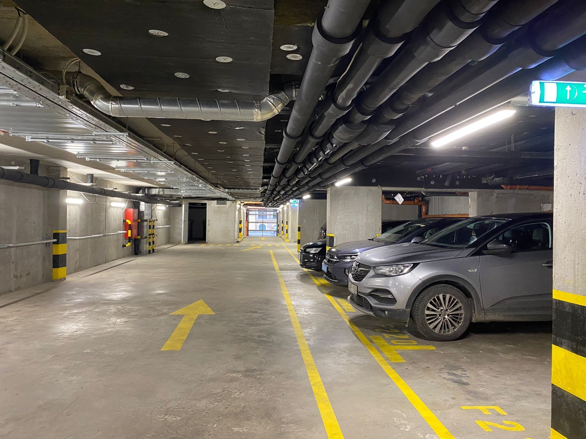 A multi-level parking garage with cars parked on the upper level.