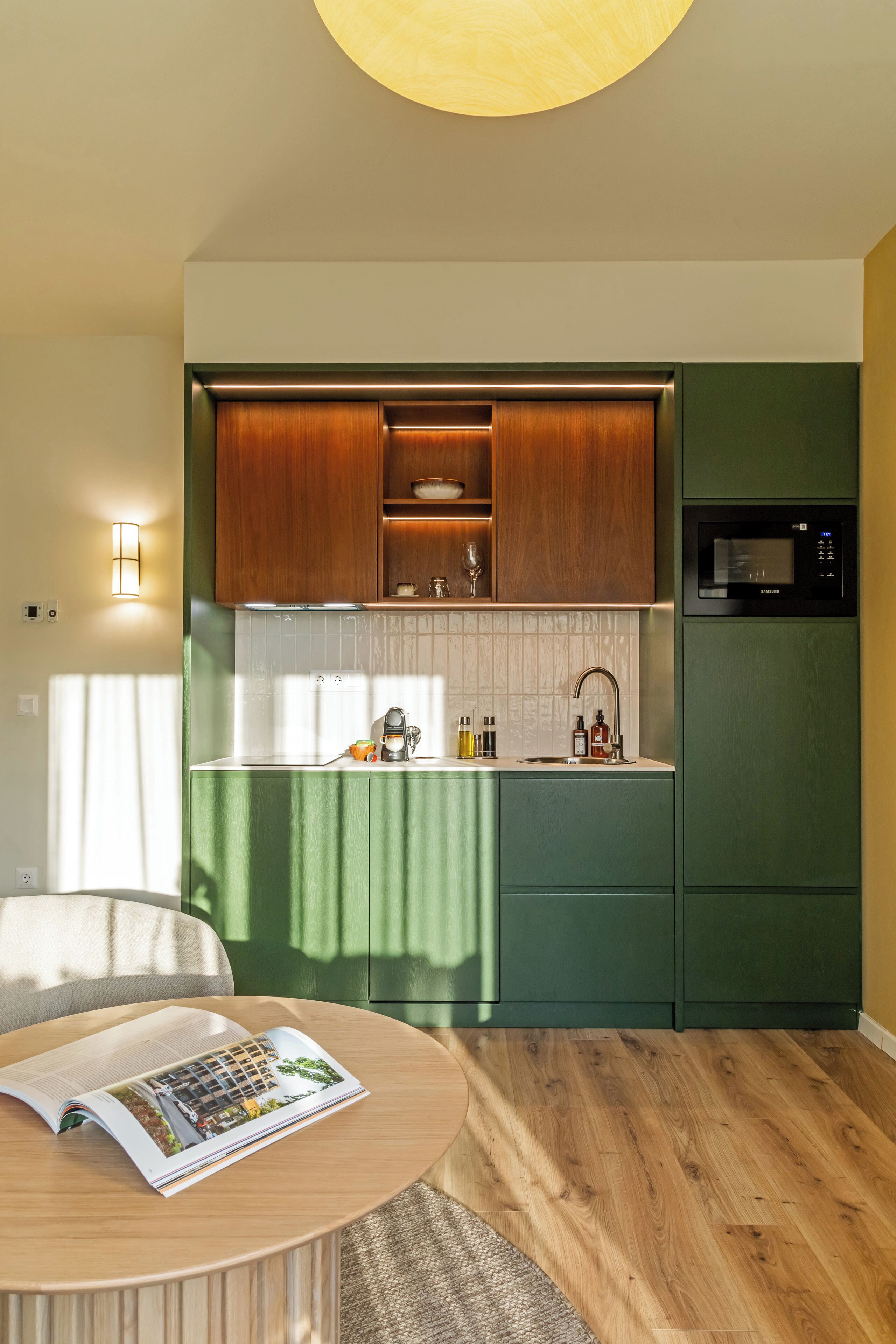 A modern kitchen with wooden cabinets, a microwave, and a coffee machine.
