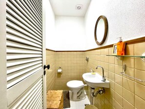 Chuveiro, toalhas de banho, sabonete, papel higiênico