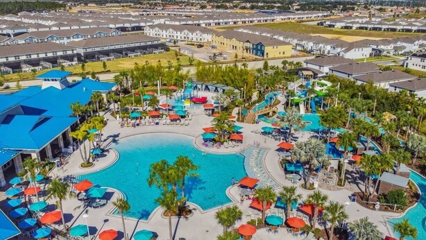 A resort with a large central pool, multiple smaller pools, and numerous sun loungers and umbrellas. - Themed 5BR Home w/ Pool · Windsor Island Resort (Davenport)