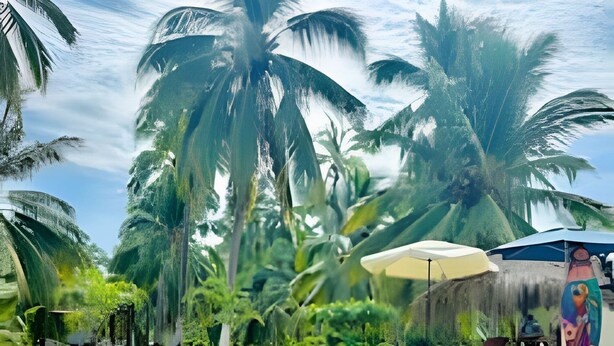 A pool area with palm trees, a mural, and a lounge chair.