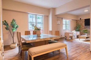 A spacious living room with a glass-top dining table, comfortable seating, and large windows. - Huge 4BR super located (Ciudad de México)