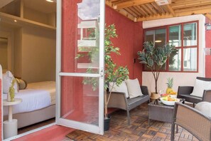 A room with a bed, a dining area with wicker furniture, and a large window. - Huge 4BR super located (Ciudad de México)
