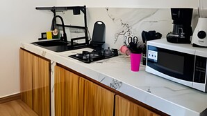 Una cocina moderna con estufa a gas, cafetera y microondas.