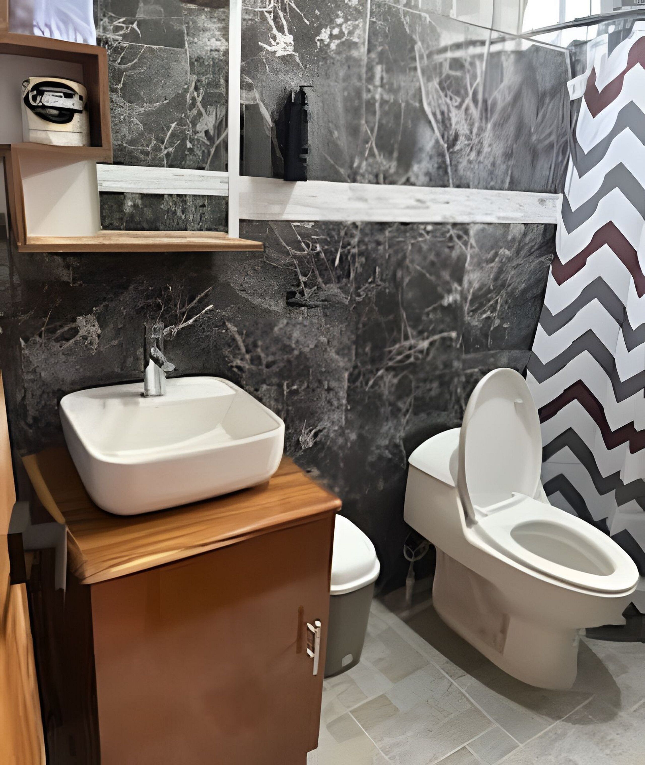 Une salle de bain avec un lavabo blanc, des toilettes et un rideau de douche.