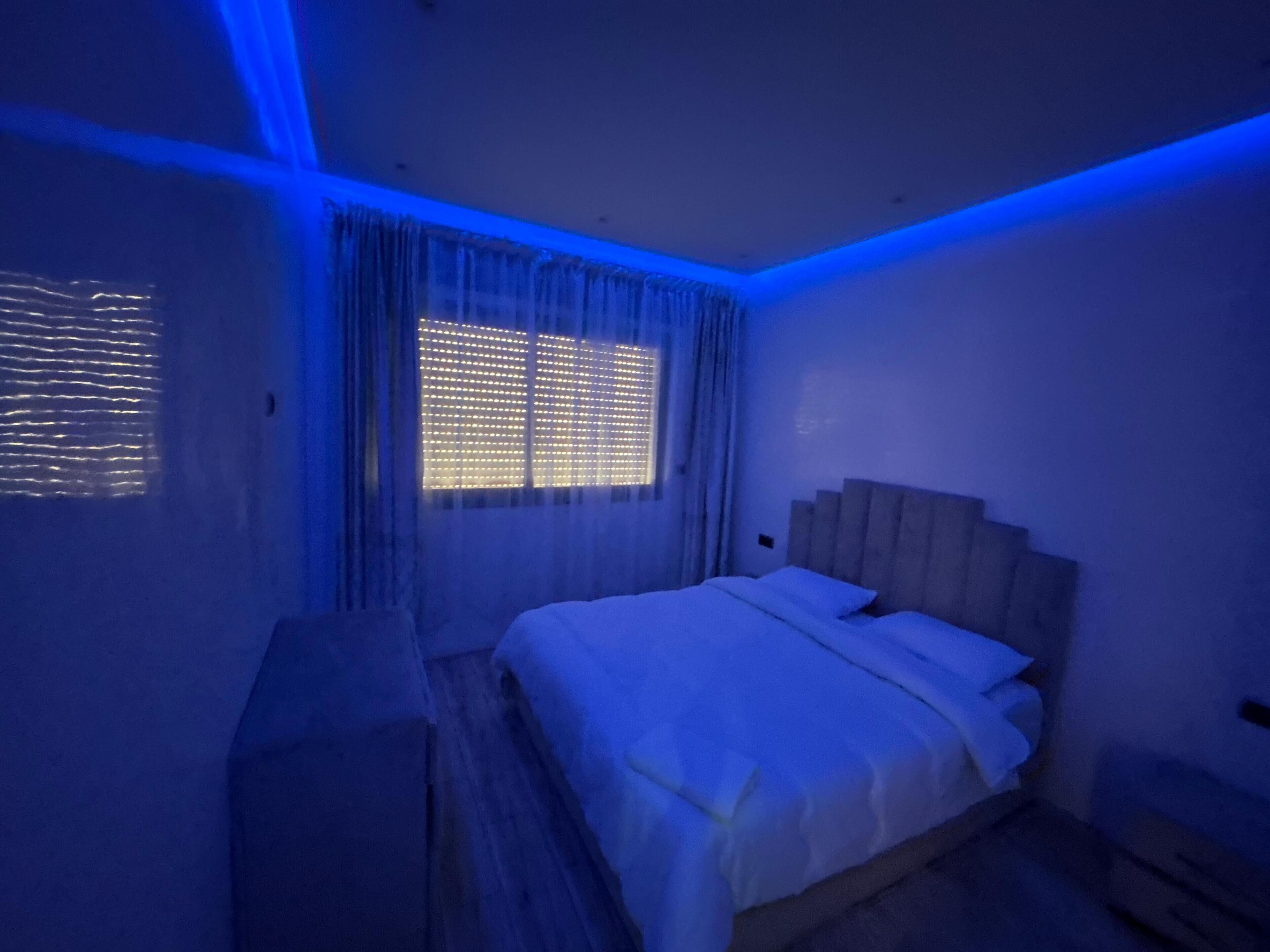A bedroom with a bed, curtains, and a window.