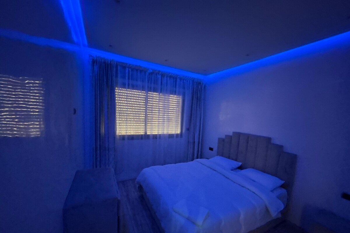 A bedroom with a bed, curtains, and a window.