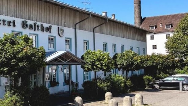 Een gebouw met een bord waarop 'Brauerei Gasthof' staat.