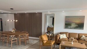 Een moderne woonkamer met een houten eettafel, een bank en een salontafel.
