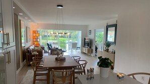 Een moderne keuken met een eethoek, grote ramen en uitzicht op de omgeving.