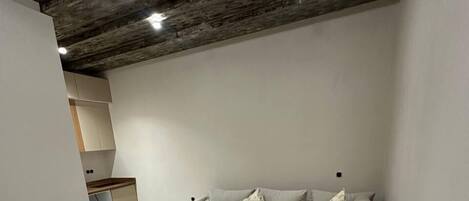 A modern living room with a sectional sofa, a wooden coffee table, and a kitchen area in the background.