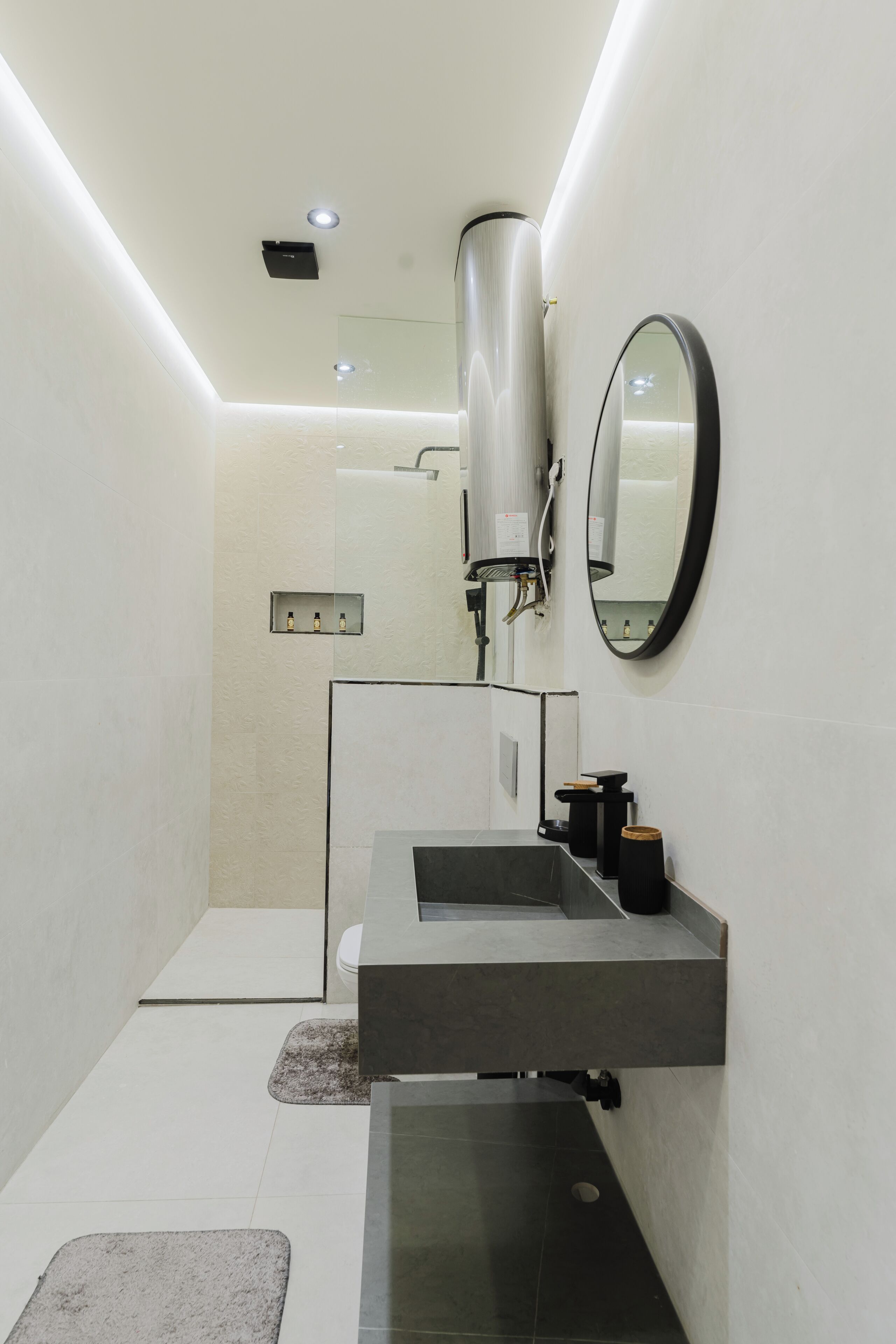Une salle de bain moderne avec un grand miroir, un lavabo intégré et un espace douche.