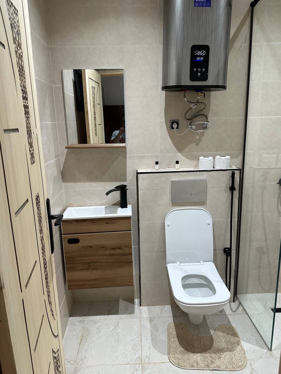 A modern bathroom with a toilet, sink, and shower.