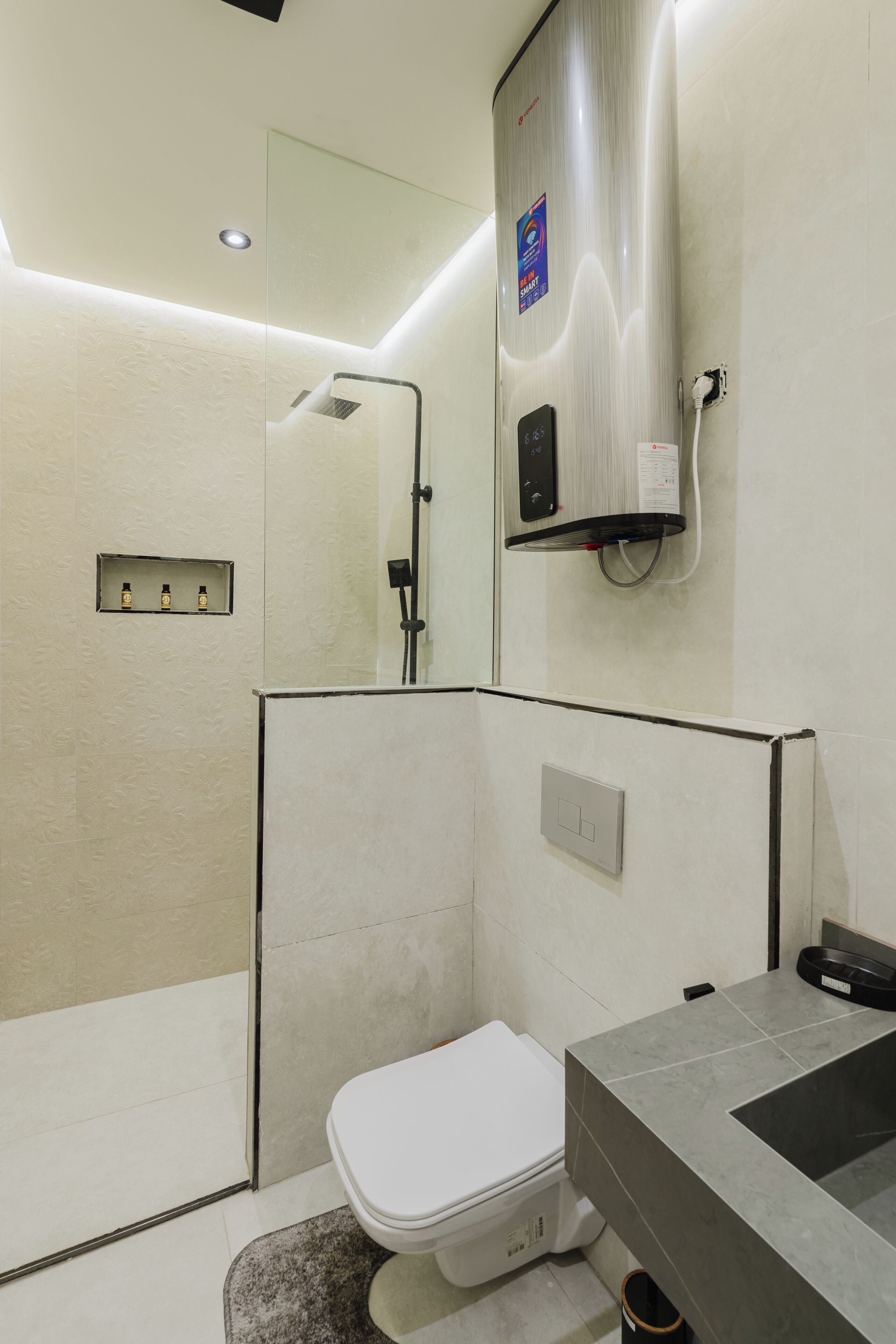 Et moderne badeværelse med bruser, toilet og en indbygget vask.