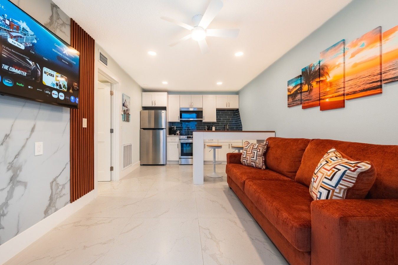 A modern living room with a sofa and a TV mounted on the wall.