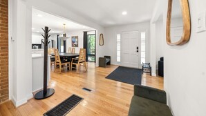 Un vaste espace de vie comprenant une table à manger, des chaises, un canapé et un grand miroir.