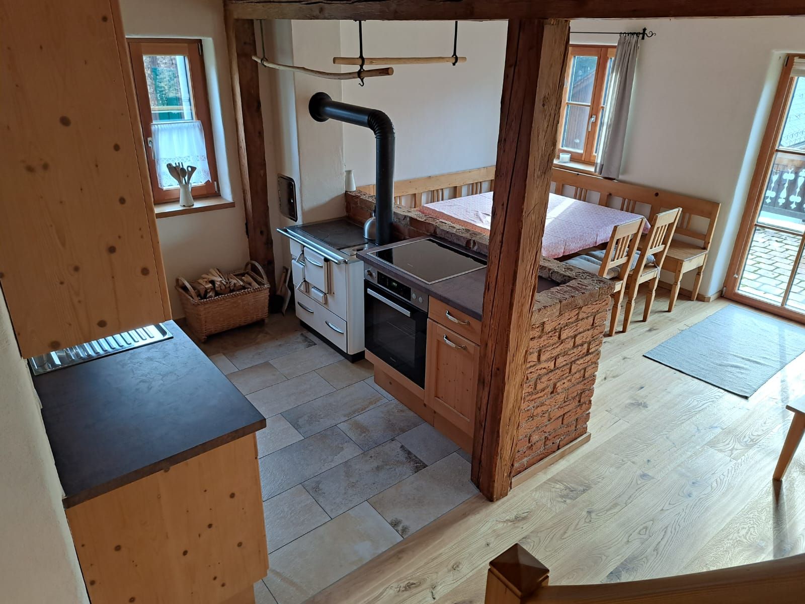 Eine kleine Küche mit Herd, Spüle und Holzschränken.