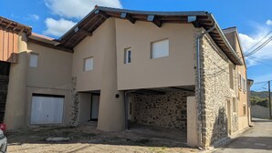 A two-story house with a stone facade and a flat roof. - Country house in the Ariege ideal for skiing, hiking, biking, snowshoeing, fishing... (Gudas)