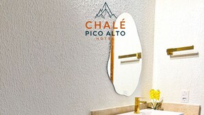 Um banheiro moderno com pia branca, espelho e porta-toalhas.
