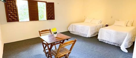Una habitación de hotel con una mesa de comedor y dos camas.