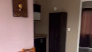 Um quarto com uma mesa de jantar de madeira e um banco, um armário escuro e chão de azulejos.