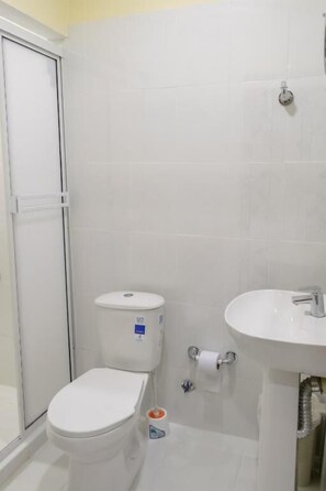 A bathroom with a toilet, a sink, and a shower. - Hostal la terraza sm (Santa Marta)