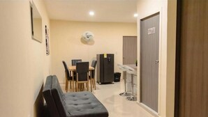 A compact hotel room with a kitchenette, a dining area, and a small seating area. - Hostal la terraza sm (Santa Marta)