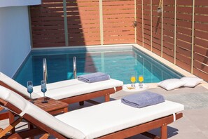 A poolside area with two sun loungers, a glass of orange juice, and a glass of water on a tray. - Comfortable 3 bedroom Villa with swimming pool and sea view. Pet-Friendly (Lefkada)