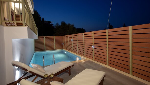 Ein Poolbereich mit Liegestühlen und einem Whirlpool.