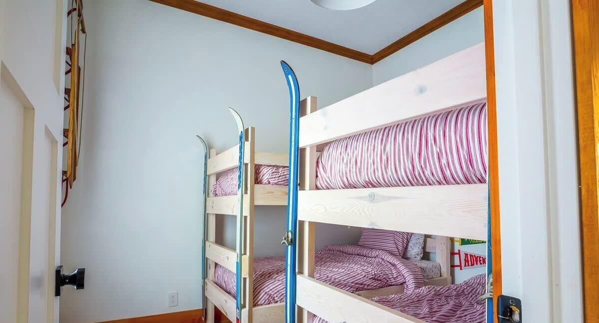 A room with bunk beds, a door, and a wall with a striped pattern.