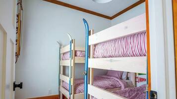 A room with bunk beds, a door, and a wall with a striped pattern.