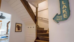 Una escalera de madera con peldaños y un cartel que indica el camino hacia el Lago.
